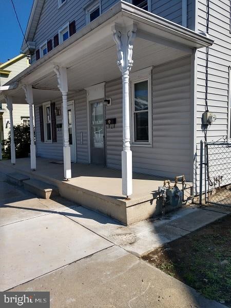 view of exterior entry featuring covered porch