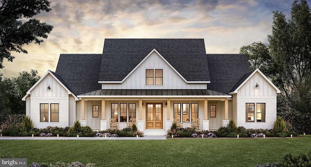 modern farmhouse style home with a porch and a yard