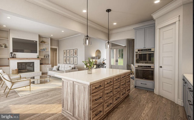 kitchen featuring gray cabinets, a kitchen island, dark wood-type flooring, hanging light fixtures, and double oven