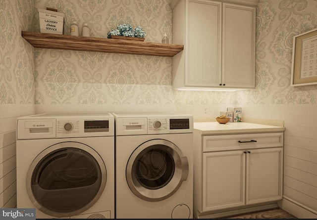 washroom featuring washing machine and dryer and cabinets