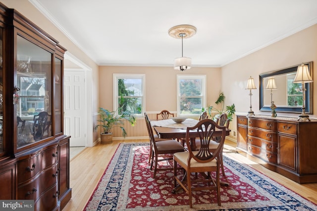 dining space with light wood-type flooring and crown molding