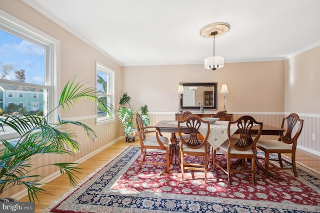 dining space with ornamental molding, a healthy amount of sunlight, and hardwood / wood-style floors