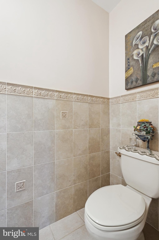 bathroom featuring tile walls and toilet