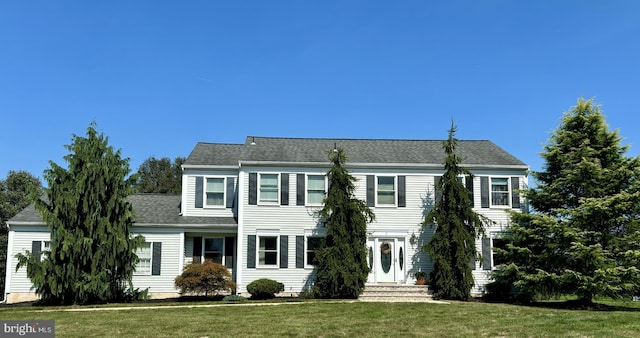 colonial-style house featuring a front yard