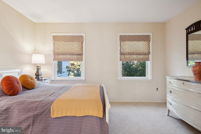 bedroom featuring light carpet and multiple windows