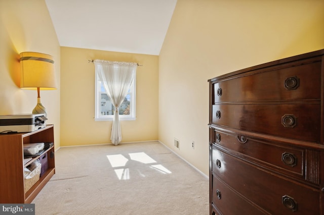 interior space with vaulted ceiling and light carpet