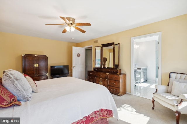 carpeted bedroom featuring ensuite bath and ceiling fan