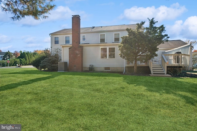 rear view of house with cooling unit, a yard, and a wooden deck