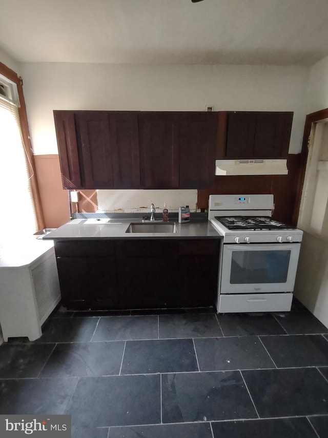 kitchen with dark brown cabinetry, white range with gas cooktop, and sink