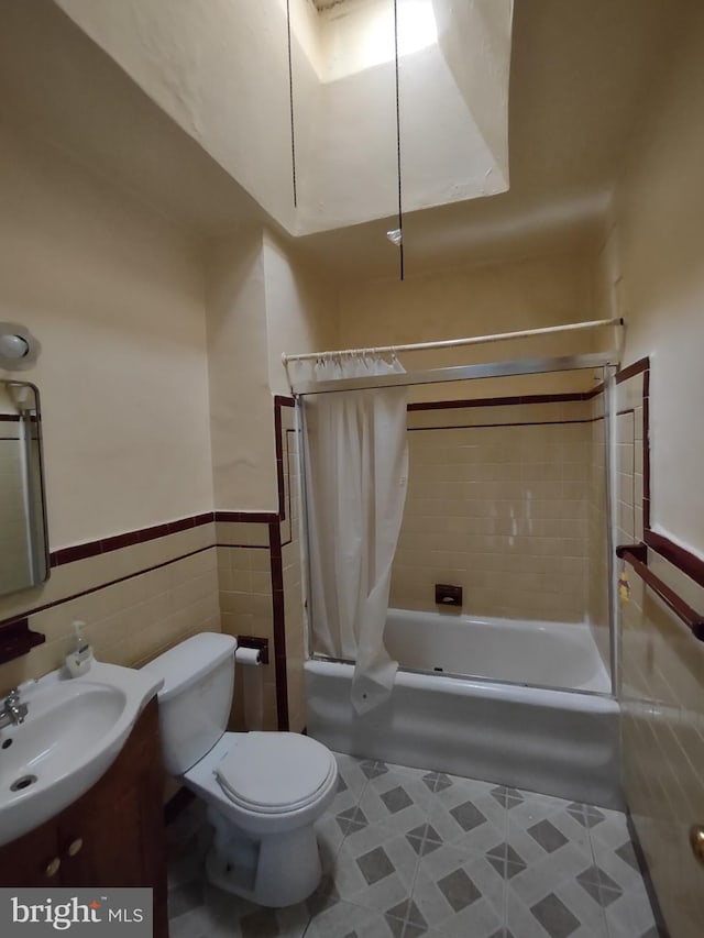 full bathroom with sink, tile patterned flooring, toilet, shower / tub combo with curtain, and tile walls