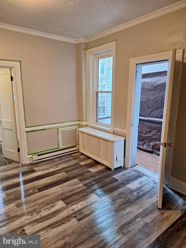 spare room with radiator, crown molding, dark hardwood / wood-style flooring, and a textured ceiling