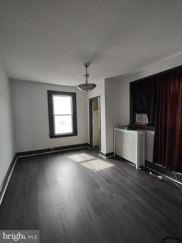 empty room featuring dark hardwood / wood-style floors and radiator