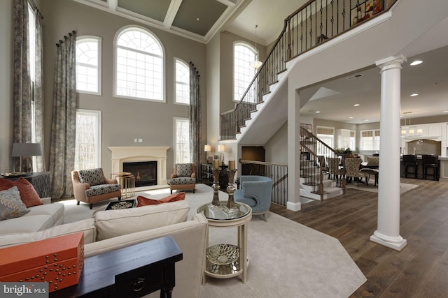 living room featuring crown molding, a high ceiling, and dark hardwood / wood-style floors