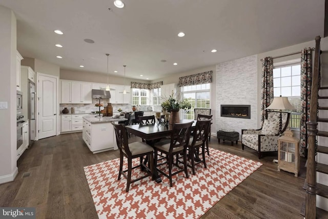 dining area featuring a fireplace and dark hardwood / wood-style flooring