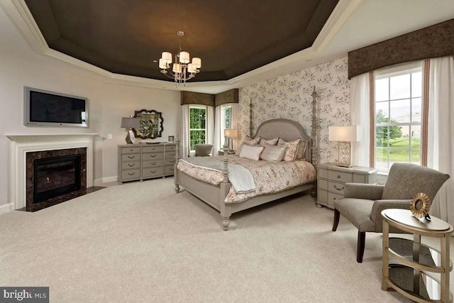 bedroom featuring a raised ceiling, multiple windows, carpet flooring, and a fireplace