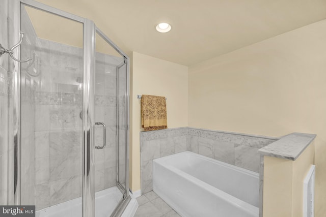 bathroom with tile patterned floors and shower with separate bathtub