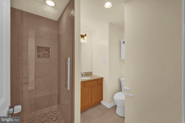 bathroom featuring vanity, tile patterned floors, toilet, and tiled shower