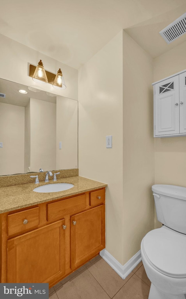 bathroom featuring vanity, tile patterned floors, and toilet