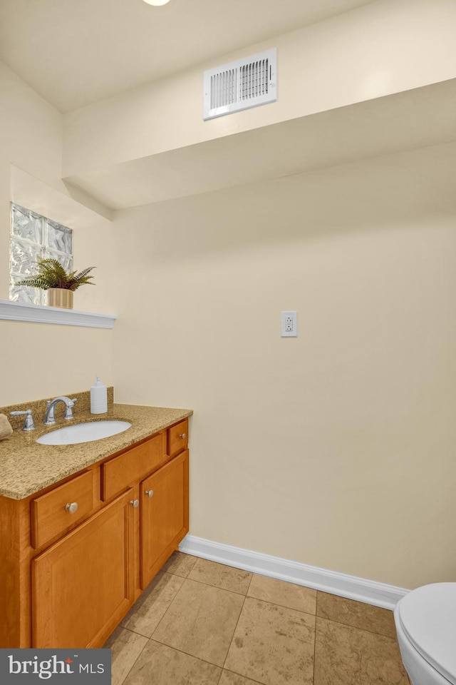 bathroom featuring tile patterned flooring, vanity, and toilet