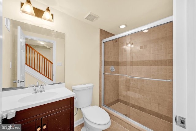 bathroom with walk in shower, vanity, and toilet