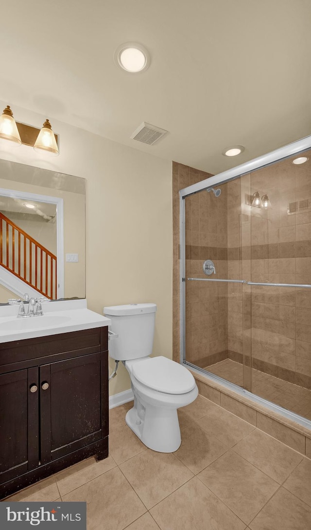 bathroom featuring vanity, tile patterned floors, toilet, and an enclosed shower