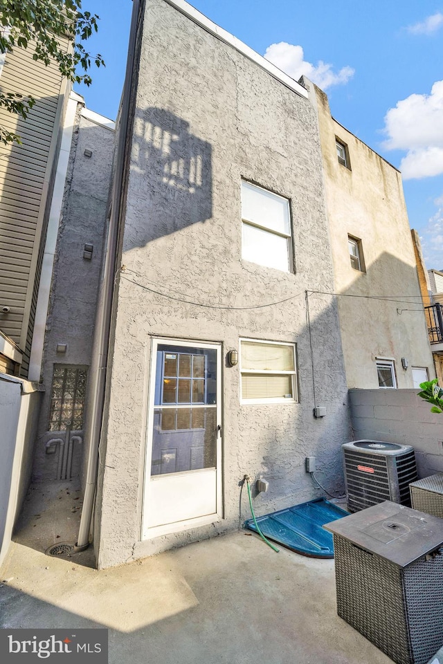 back of house with central air condition unit and a patio