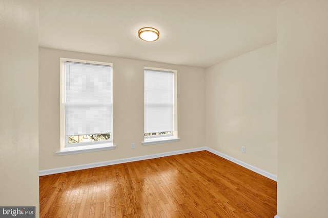 unfurnished room with hardwood / wood-style flooring and plenty of natural light