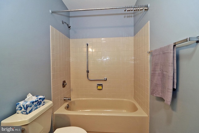 bathroom with tiled shower / bath combo and toilet