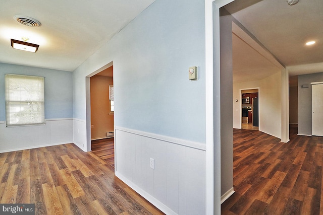 hall featuring baseboard heating and dark hardwood / wood-style floors