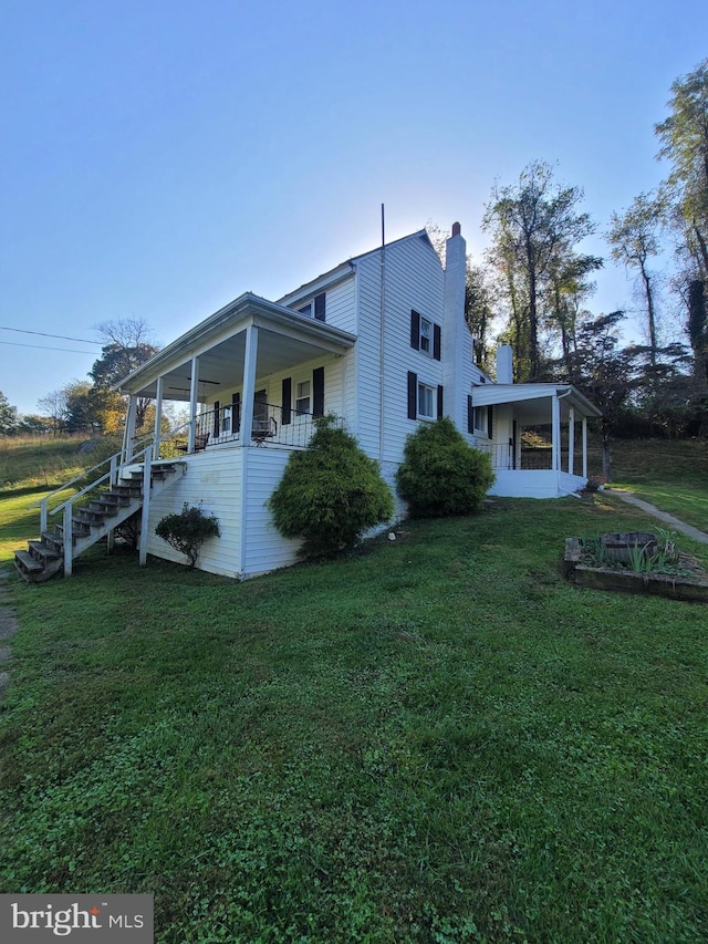 view of home's exterior featuring covered porch and a lawn