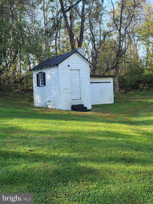 view of outbuilding featuring a lawn