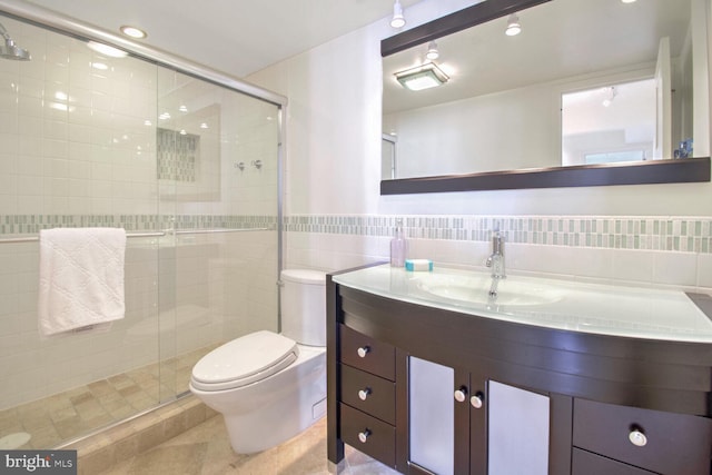 bathroom featuring an enclosed shower, toilet, tile patterned floors, tile walls, and vanity