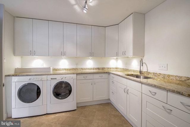 laundry area featuring sink, washer and dryer, light tile patterned floors, and cabinets