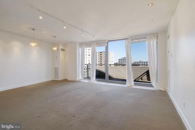 carpeted spare room featuring rail lighting