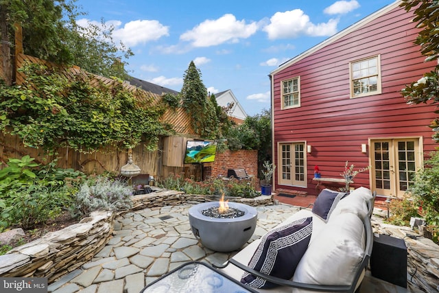 view of patio / terrace with french doors and a fire pit