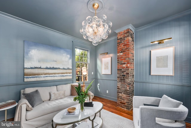 living room featuring ornamental molding, a chandelier, and hardwood / wood-style flooring