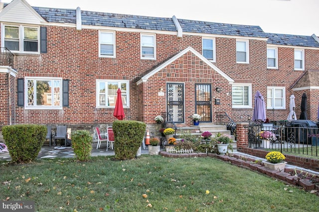 view of property with a patio area and a front lawn