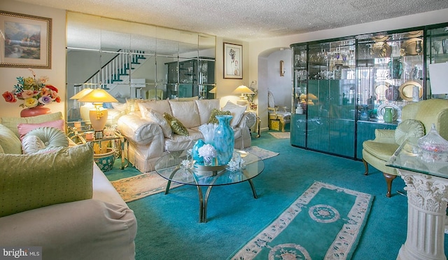1144 E Slocum St, Philadelphia, PA 19150 - living room featuring arched walkways, stairway, a textured ceiling, and carpet flooring
