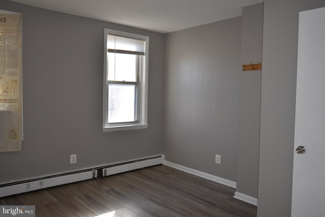 unfurnished room with a baseboard radiator and dark hardwood / wood-style flooring