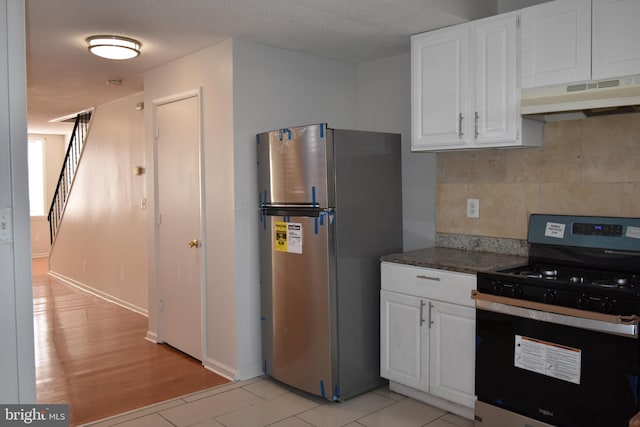 kitchen with gas range, exhaust hood, light wood-type flooring, white cabinets, and stainless steel refrigerator