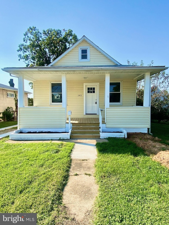 bungalow-style house with covered porch and a front lawn