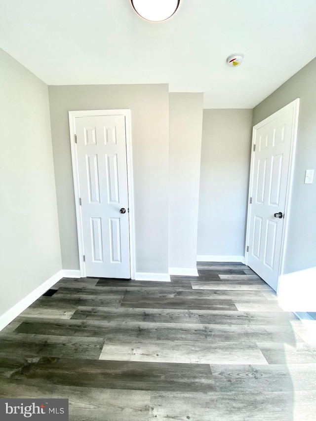 unfurnished bedroom with dark wood-type flooring