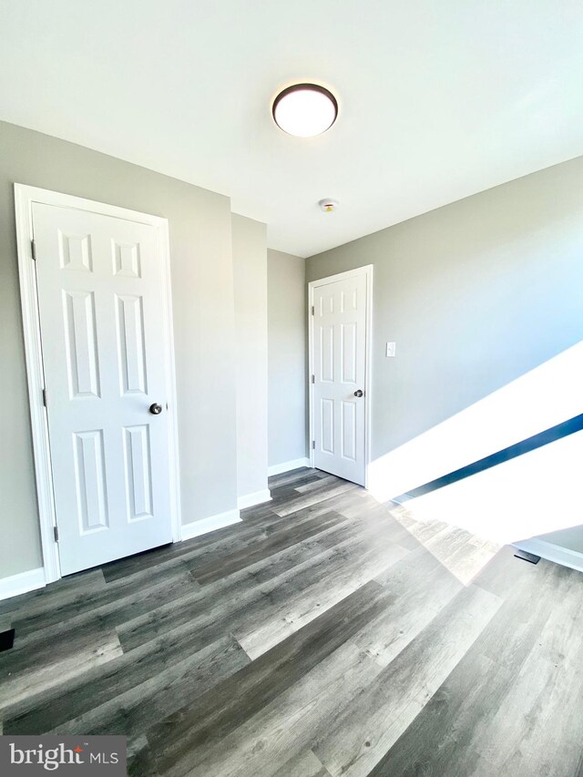 spare room with dark wood-type flooring