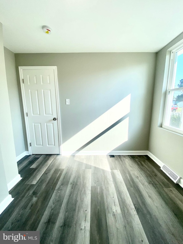 unfurnished room featuring dark wood-type flooring