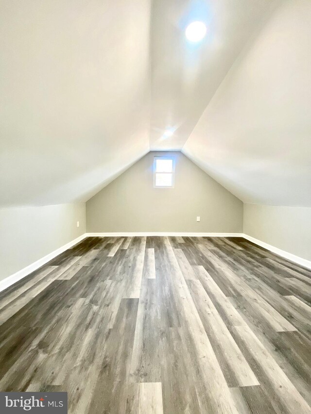 additional living space with lofted ceiling and dark wood-type flooring