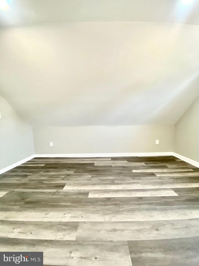 bonus room with wood-type flooring and vaulted ceiling