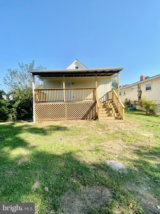 back of house featuring a deck and a lawn