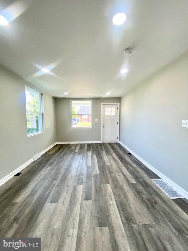 spare room with dark wood-type flooring and a wealth of natural light