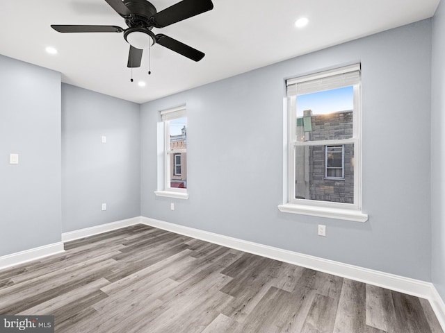 unfurnished room featuring light hardwood / wood-style floors, ceiling fan, and plenty of natural light