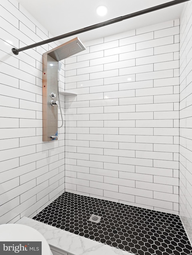 bathroom with toilet and tiled shower